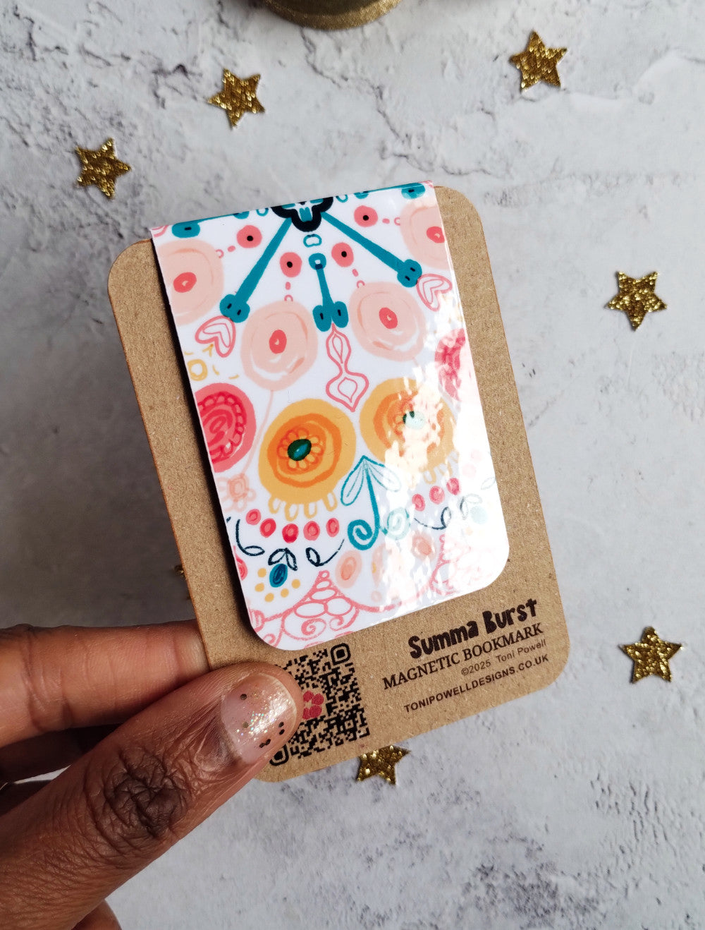 Summa Burst Magnetic bookmark with bright colourful pattern design held to show the glossy laminate