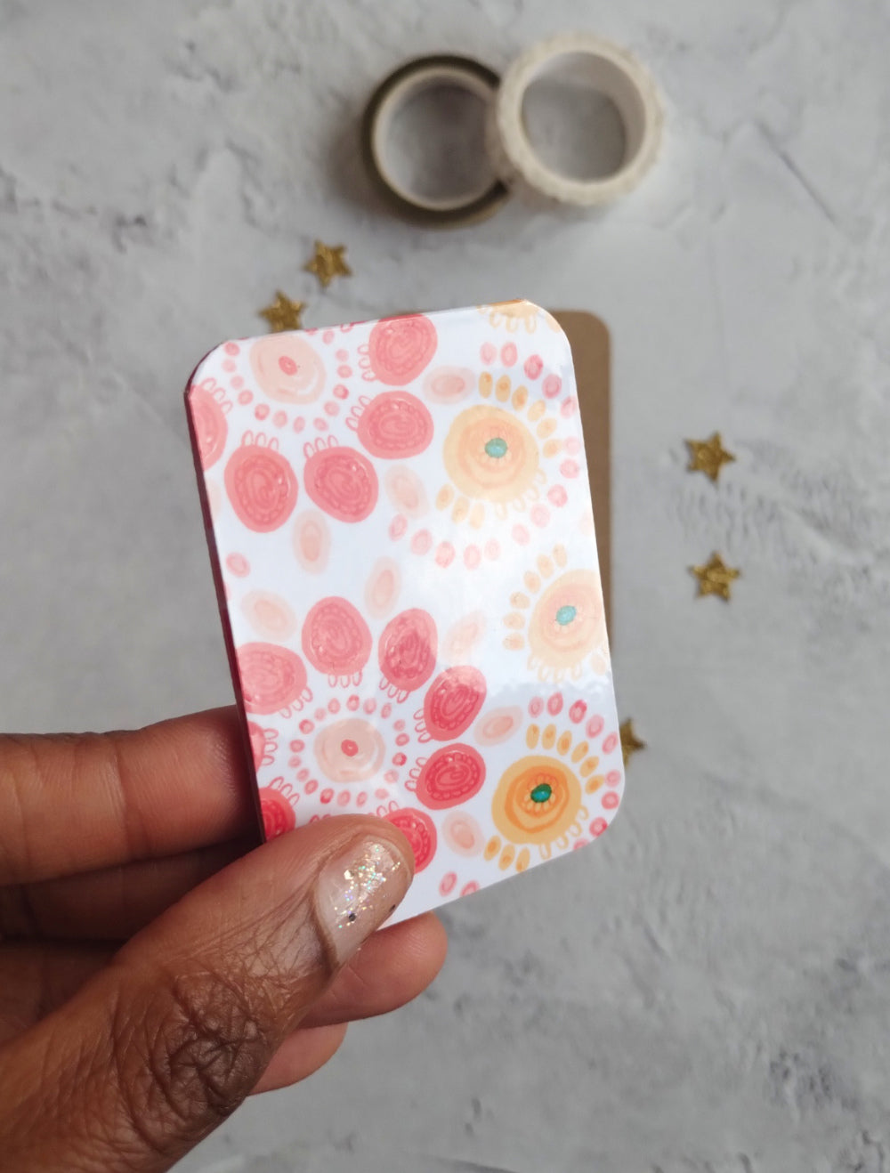 Hand holding Summa Carnival Magnetic bookmark with bright colourful pattern design.