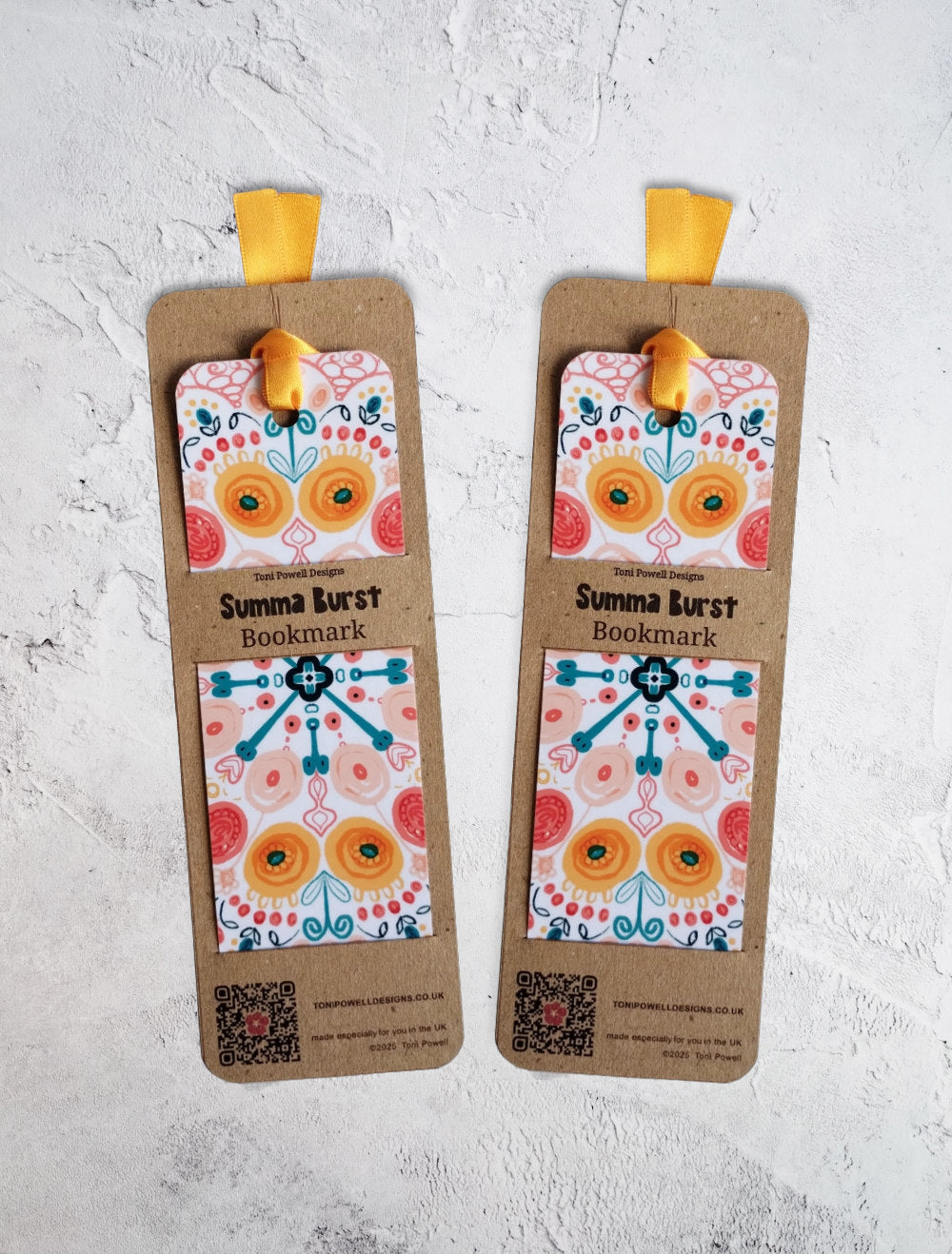 Summa Burst brightly patterned set of two bookmarks, embellished with a sunset yellow ribbon, in packaging