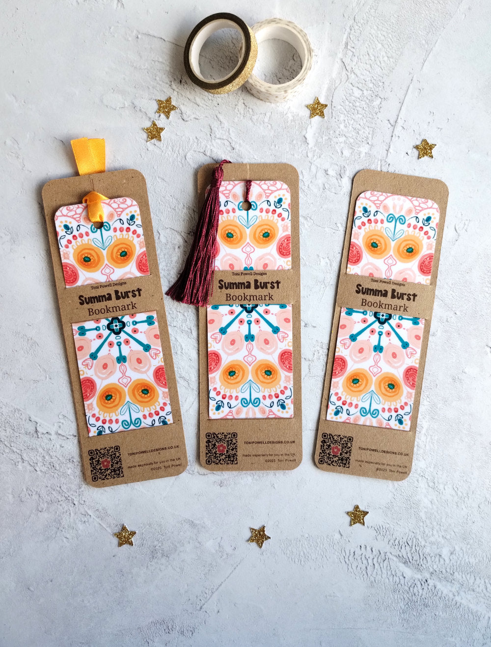 Three colourful patterned bookmarks from the Summa Burst range on a textured surface with decorative tape and stars.
