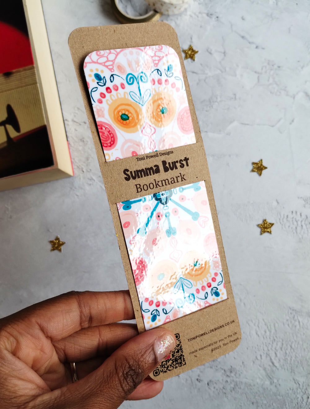 Glossy Summa Burst boomark held to show the laminated glossy finish