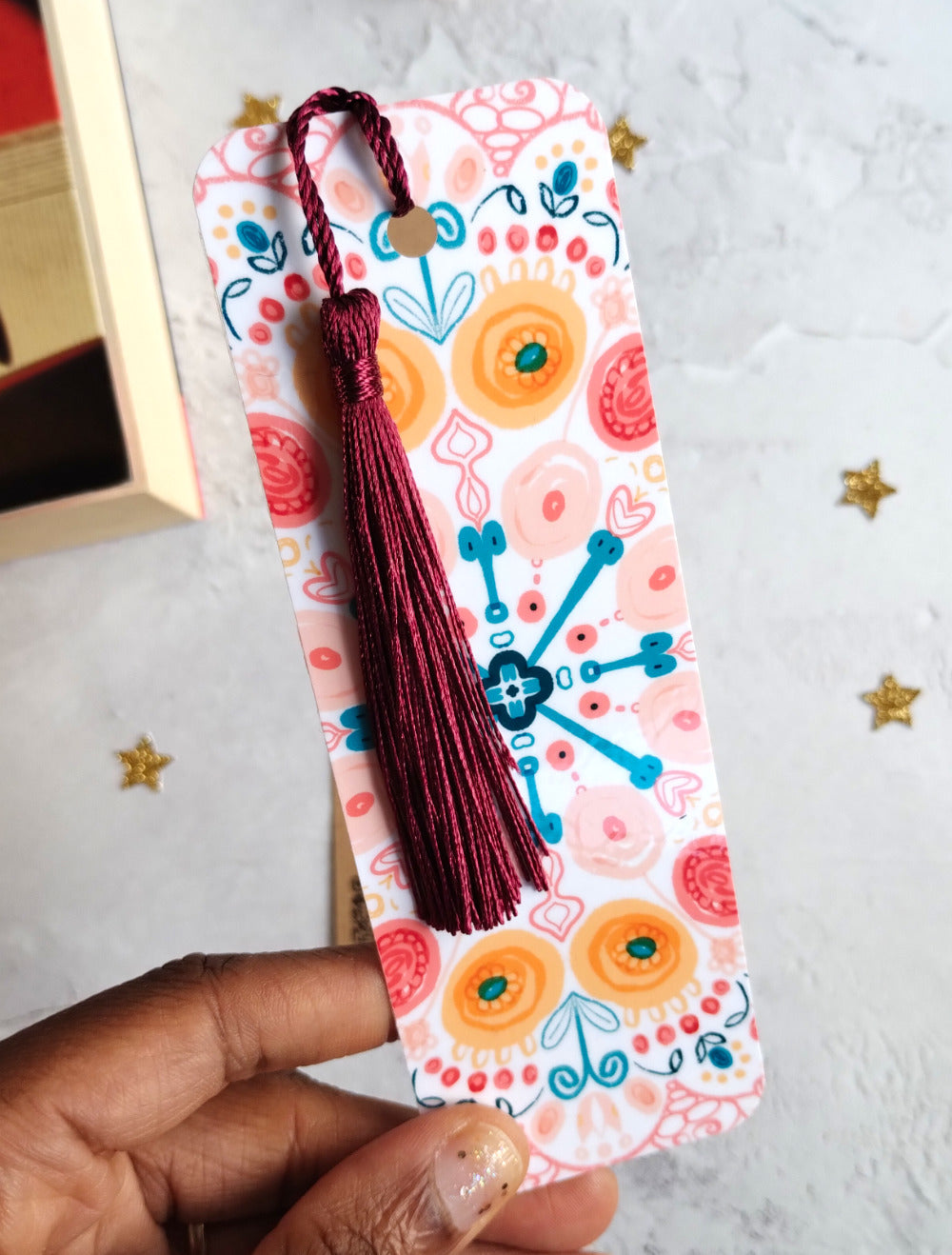Close up of Summa Burst brightly patterned bookmark embellished with a beetroot red tassel