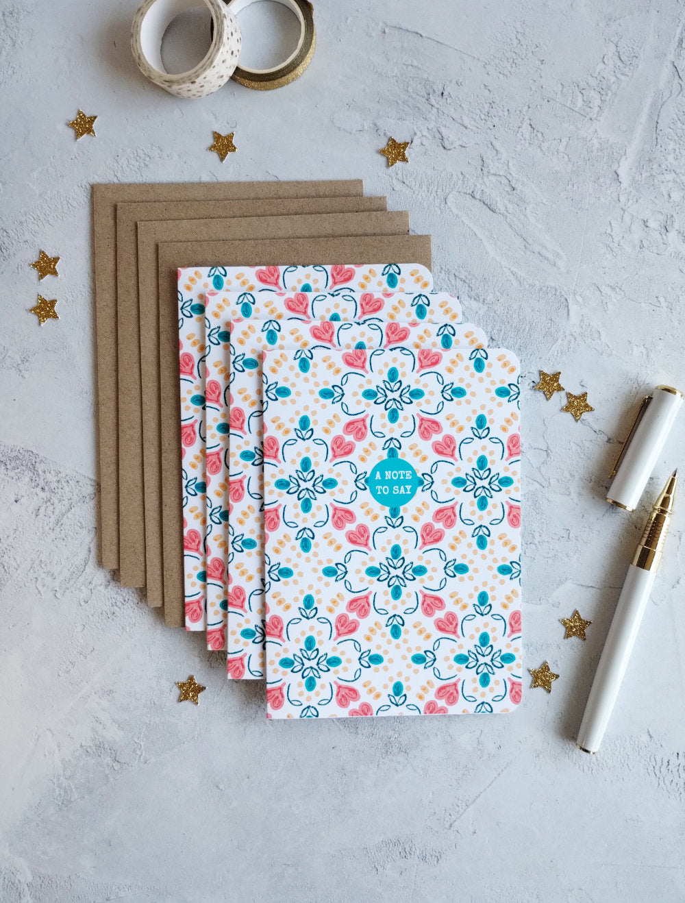 Set of patterned Summa Tiles note cards with a pen and tape on a textured surface