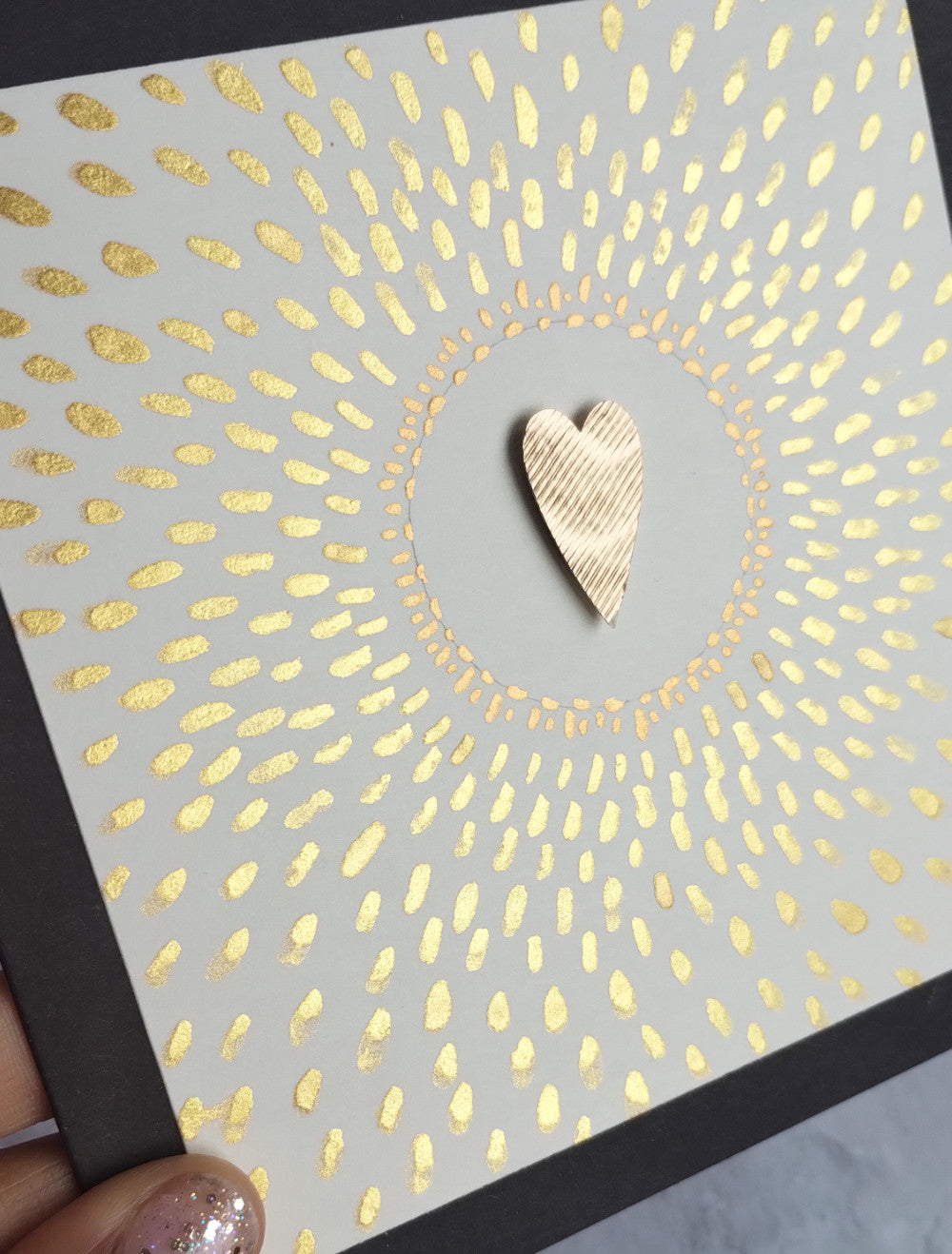 Love Shines Framed artwork with a heart design on a textured surface surrounded by pink petals.