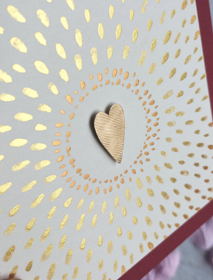 Love Shines Valentine's Card with gold heart design on a raspberry background with pink petals