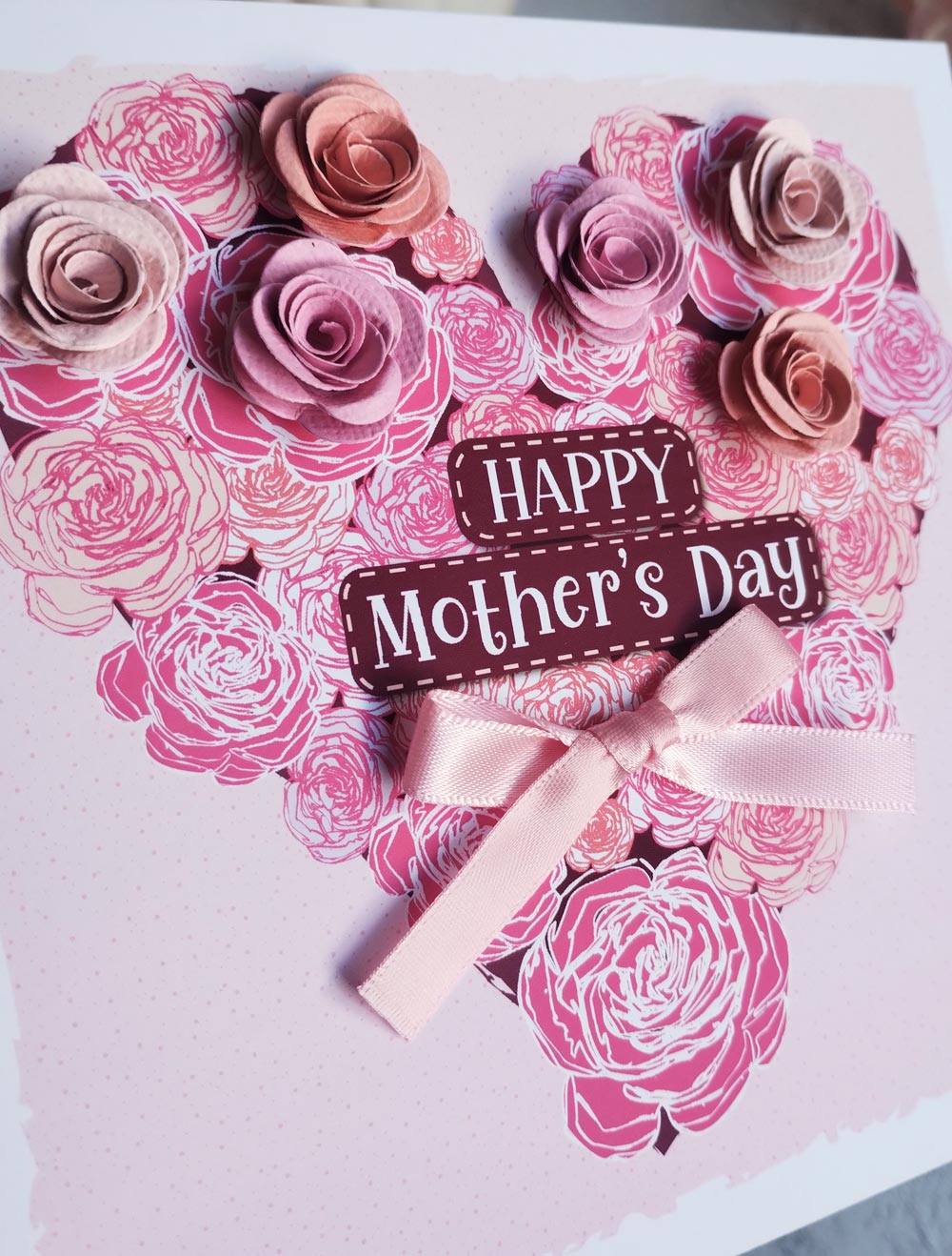 Pink Mother's day heart decorated with and-rolled paper flowers and hand-tied satin bow