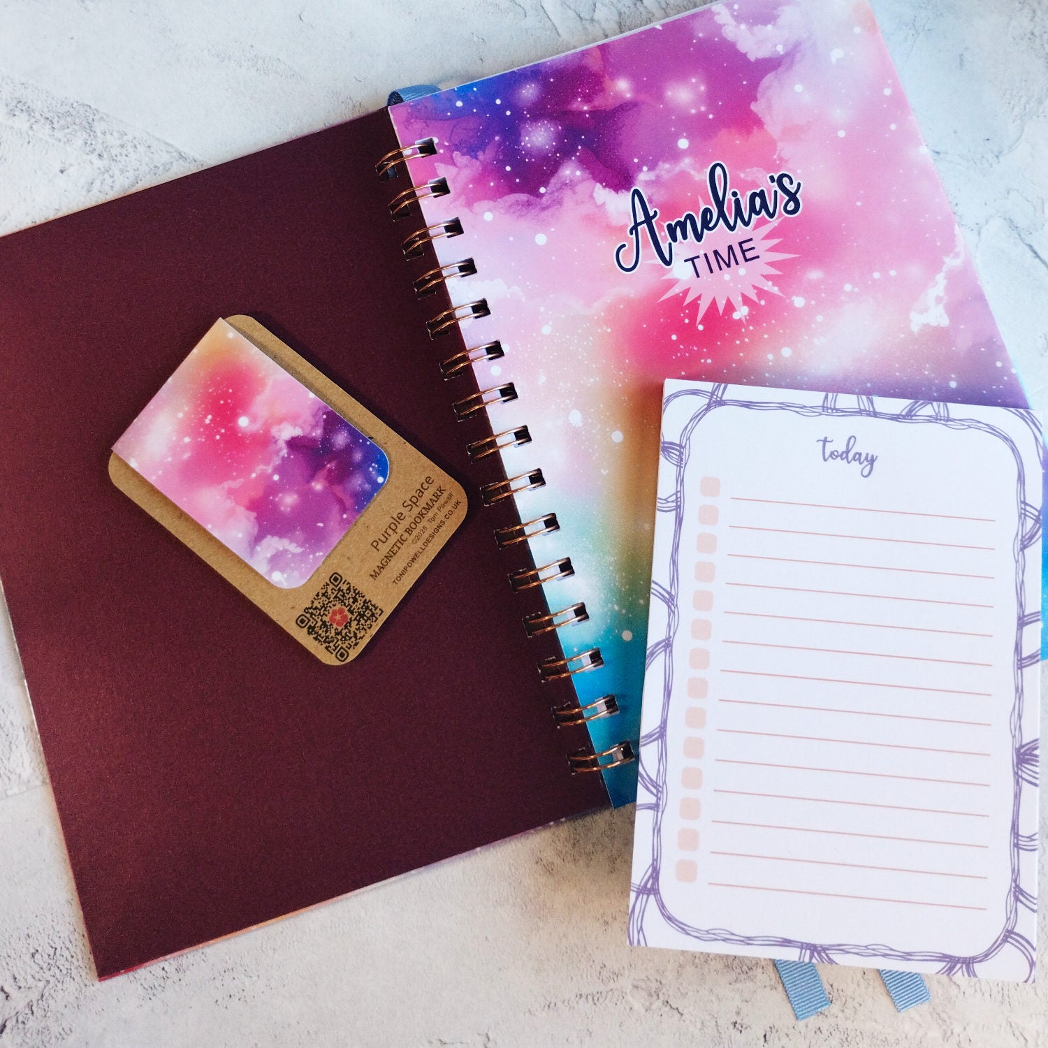 The Dream Space open A5 notebook with peaarlescent maroon inner cover, a magnetic bookmark and A6 notepad