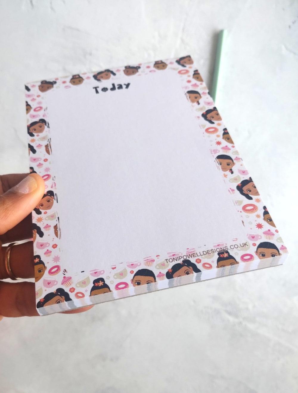 Notepad with cute faces and sweet treats design on a white surface