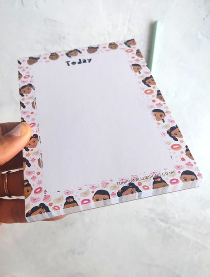 Notepad with cute faces and sweet treats design on a white surface
