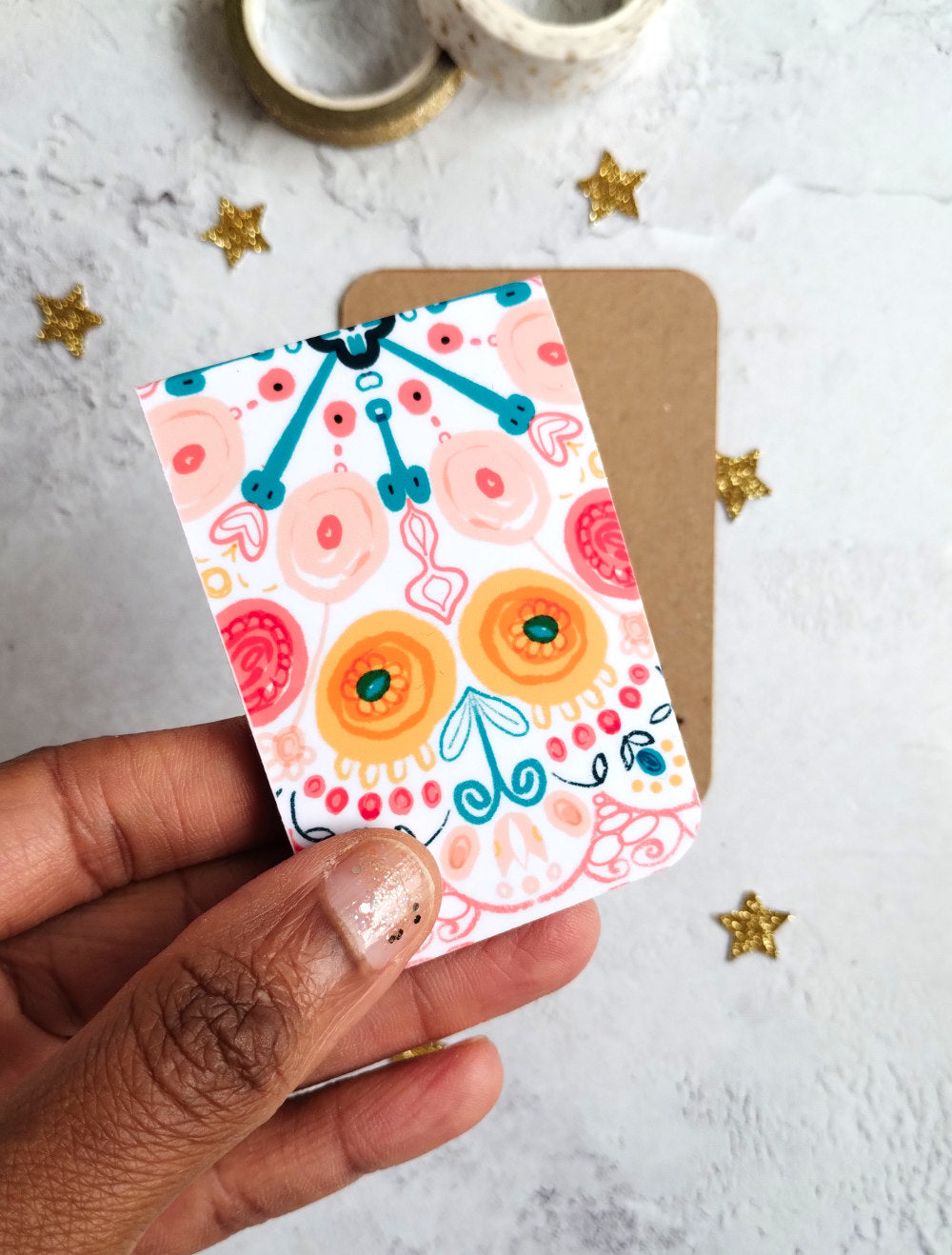 Hand holding Summa Burst Magnetic bookmark with bright colourful pattern design.