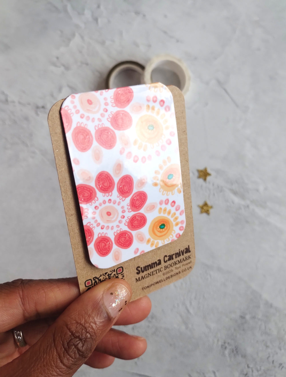 Summa Carnival Magnetic bookmark with bright colourful pattern design held to show the glossy laminate