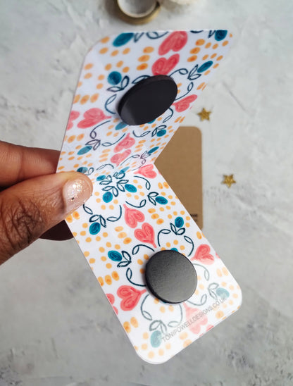 Unfolded Summa Love Magnetic bookmark with bright heart pattern design.