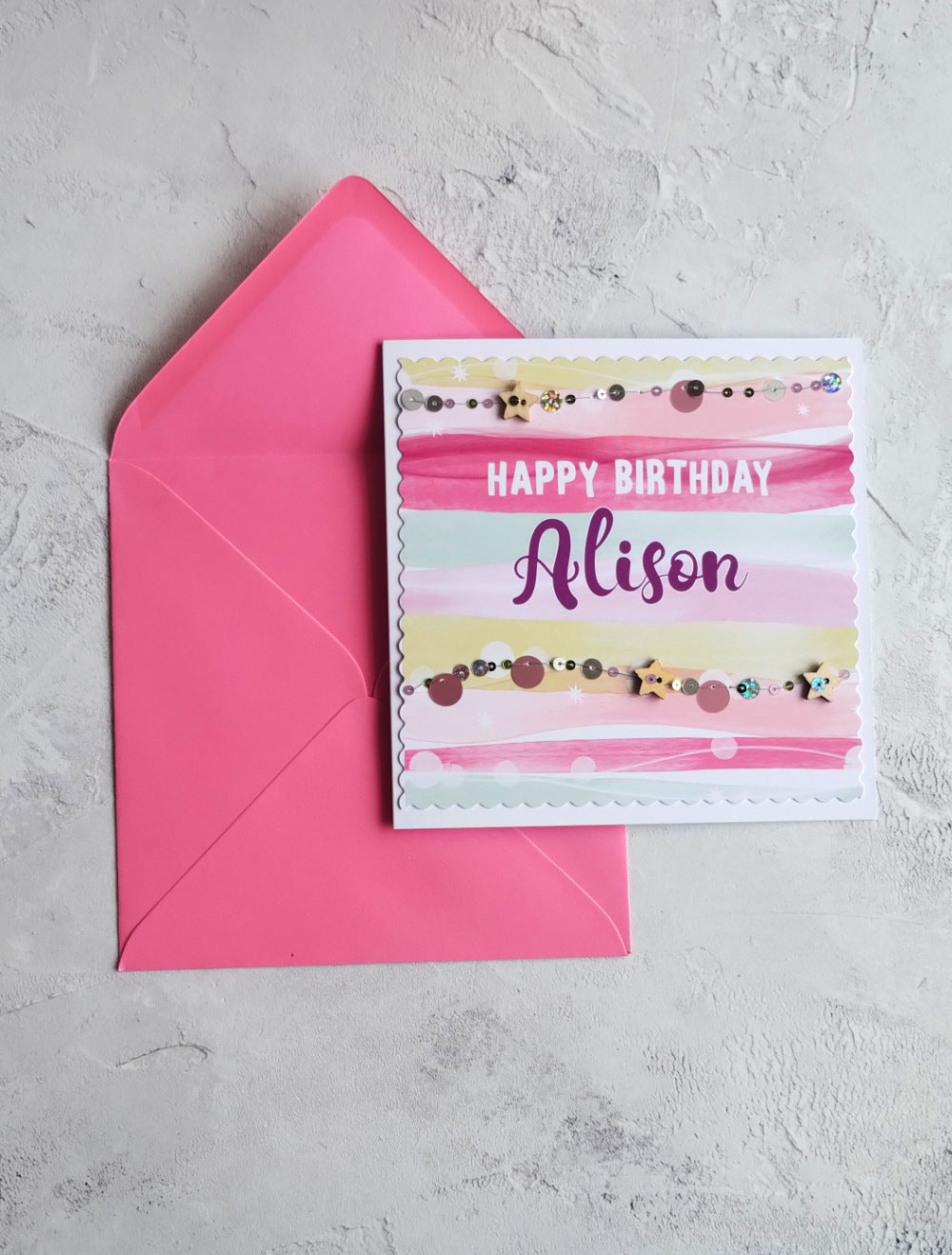 Personalised Happy Birthday card with a pink envelope on a gray surface