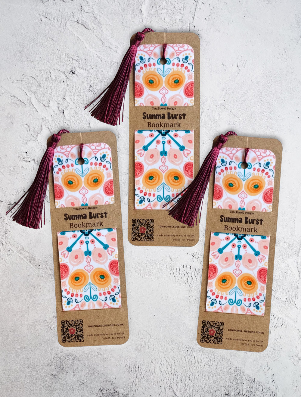 Summa Burst brightly patterned set of three bookmarks, embellished with a beetroot red tassel, in packaging
