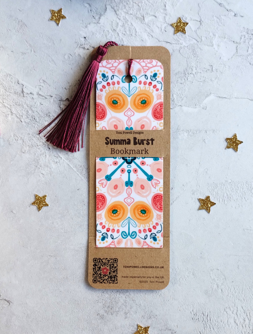 Summa Burst brightly patterned bookmark embellished with a beetroot red tassel, in packaging