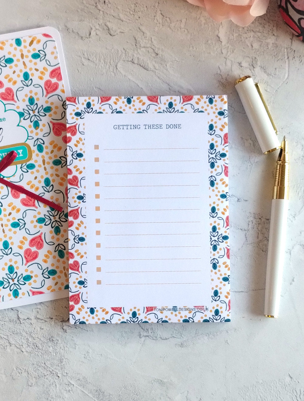Heart pattern notepad with a pen and matching card on a textured surface